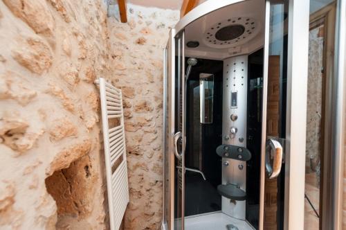 a shower in a room with a stone wall at Can Rovey in Inca