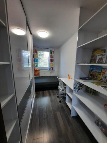 a room with white shelves and a desk and a window at Prievidza Home in Prievidza