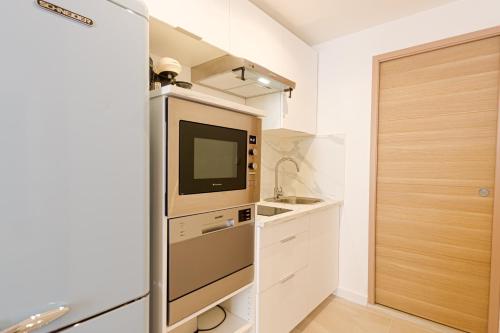 une petite cuisine avec une télévision et un évier dans l'établissement Très jolie deux chambres Neuf Climatisé - Centre ville historique, à Montpellier