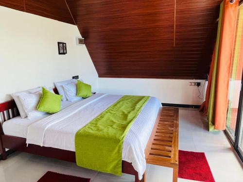 a bedroom with a bed with green and white sheets at Cloudy Hill Cottage in Ella