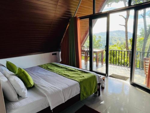 a bedroom with a bed and a large window at Cloudy Hill Cottage in Ella
