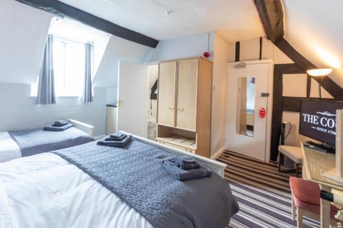 a room with two beds and a tv in it at The Court in Bridgnorth