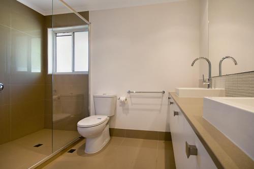 a bathroom with a toilet and a sink at Skippers Cove Waterfront Resort in Noosaville