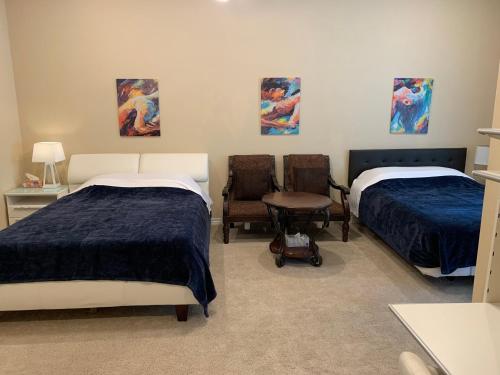 a room with two beds and a chair at LuxHome Suites in Mansion in Riverside