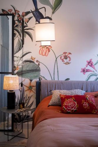 une chambre avec un lit avec une fresque florale sur le mur dans l'établissement Casa Grande Motte, à La Grande Motte