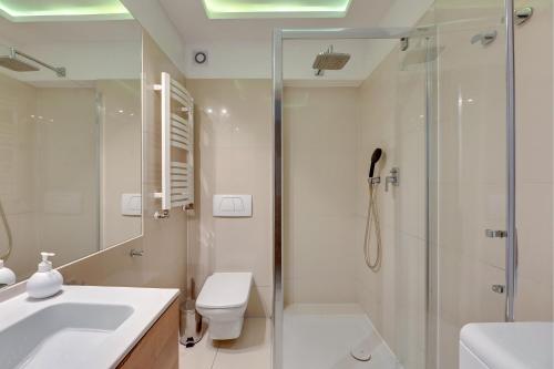 a bathroom with a shower and a toilet and a sink at Bryza - apartament w Sopocie by Grand Apartments in Sopot