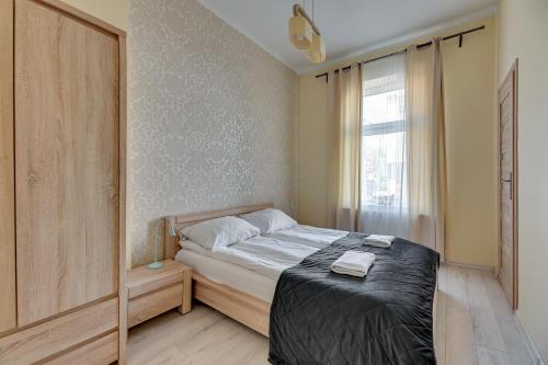 a small bedroom with a bed and a window at Bryza - apartament w Sopocie by Grand Apartments in Sopot