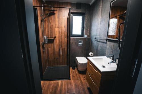 a bathroom with a shower and a toilet and a sink at Bobrowe Wzgórza Resort in Jelenia Góra