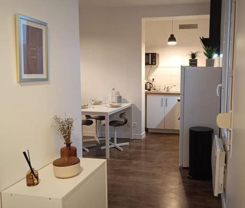 une cuisine blanche avec une table et un réfrigérateur dans l'établissement Charmant T2 - Proche Gare & Centre-Ville - Fibre, à Compiègne
