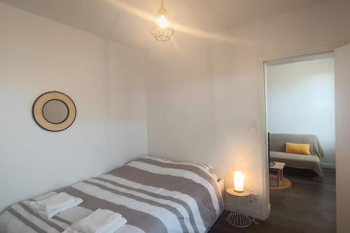 - une chambre avec un lit, un miroir et une lampe dans l'établissement Charmant T2 - Proche Gare & Centre-Ville - Fibre, à Compiègne