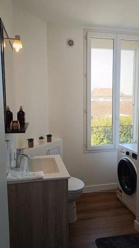 une salle de bain avec un lavabo et des toilettes et une fenêtre dans l'établissement Charmant T2 - Proche Gare & Centre-Ville - Fibre, à Compiègne