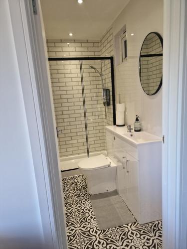 a bathroom with a toilet and a sink and a shower at Deluxe Cabin wrapped by nature in Dartford