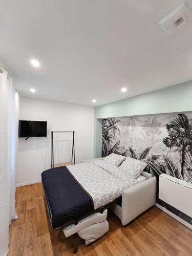 - une chambre avec un lit et un mur orné d'une fresque murale dans l'établissement Studio cosy au coeur de Cambrai, à Cambrai