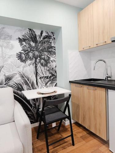 une cuisine avec une fresque murale sur les palmiers dans l'établissement Studio cosy au coeur de Cambrai, à Cambrai