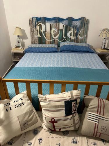 una camera da letto con un letto con un piumone e cuscini blu di Villa Eco-Chic a Carini