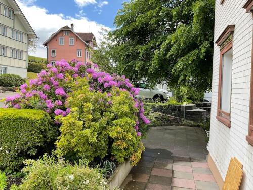 a garden with purple flowers and a house at 02 - Gästehaus Erika - Hundwil - Appenzellerland in Hundwil