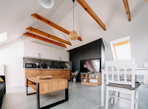 a living room with a table and a kitchen at Widokowy 2 in Sandomierz