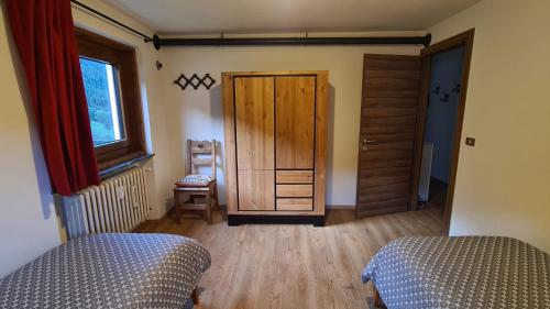 a bedroom with two beds and a wooden door at Chez Ferdinand in Valtournenche