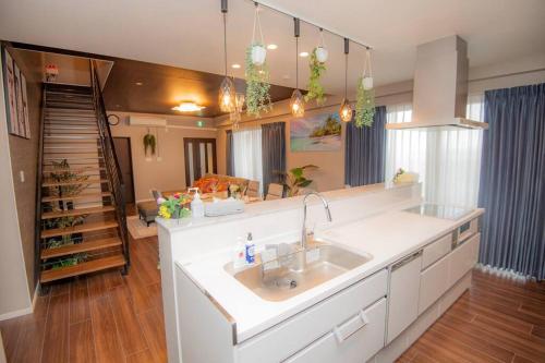 uma cozinha com pia e uma sala de estar em umikaze 2024年10月Open 新築物件 em Uruma
