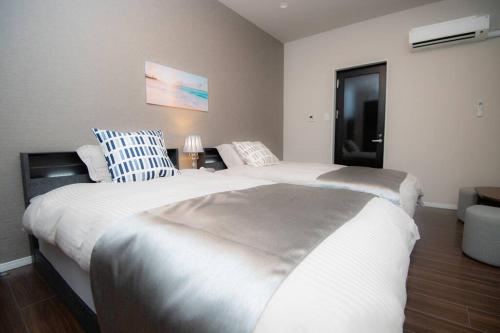 a bedroom with two beds and a couch at umikaze 2024年10月Open 新築物件 in Uruma