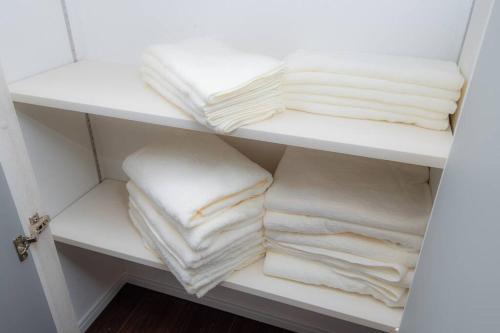 a closet with white towels on a shelf at umikaze 2024年10月Open 新築物件 in Uruma