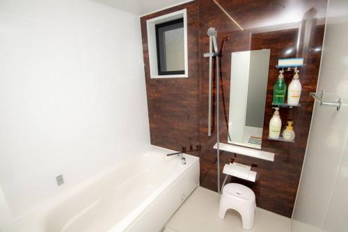 a bathroom with a tub and a sink and a mirror at umikaze 2024年10月Open 新築物件 in Uruma