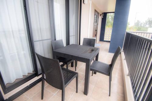a black table and chairs on a balcony at umikaze 2024年10月Open 新築物件 in Uruma