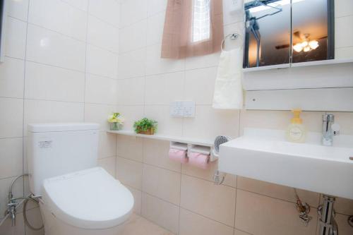 a white bathroom with a toilet and a sink at umikaze 2024年10月Open 新築物件 in Uruma