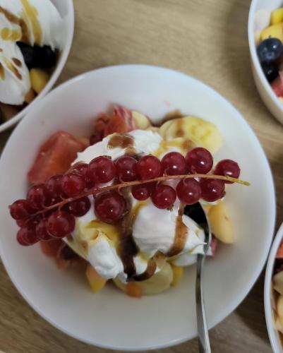 a white plate with a dessert with fruit and whipped cream at Adac Boutique Hotel in Bucharest