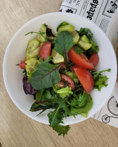 a salad in a white bowl on a table at Adac Boutique Hotel in Bucharest