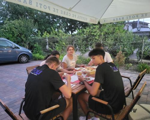 a group of people sitting at a table eating food at Adac Boutique Hotel in Bucharest