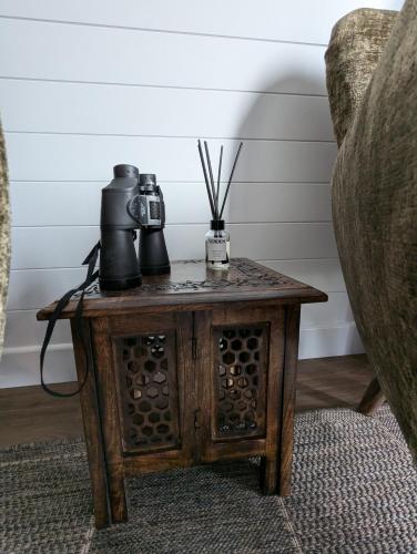 a coffee table with binoculars and a camera on it at BluePigeons Pods Roag Dunvegan in Lonmore