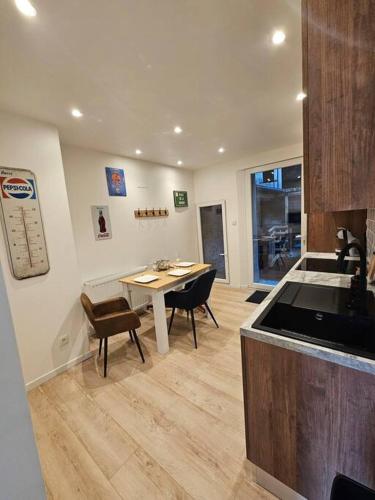 une cuisine avec une table et des chaises dans une pièce dans l'établissement Maison avec garage et terrasse quartier historique, à Épinal