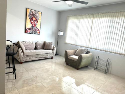 a living room with a couch and a chair at The Shelton - Sinclair in Montego Bay