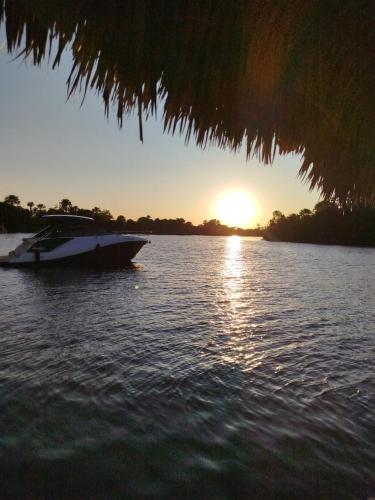 a boat sitting in the water at sunset at Marcone Lima - Chalés in Barreirinhas
