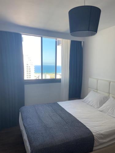 a bedroom with a bed with a view of the ocean at GRAND SAPPHIRE HOTEL CASINO and RESIDENTS 1 Bedroom Suit with Superior Sea View and Free Internet in Áyios Yeórgios