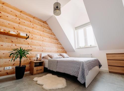 a bedroom with a bed and a wooden wall at Widokowy 1 in Sandomierz