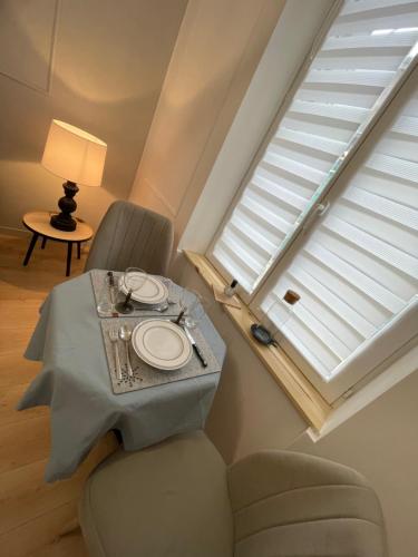 un salon avec une table et une fenêtre dans l'établissement Appartement champenois centre-ville, à Reims