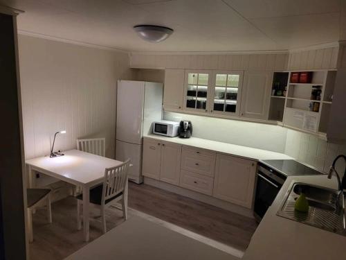 a kitchen with a table and a white refrigerator at Hareid in Hareid