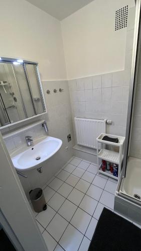 a white bathroom with a sink and a mirror at Emilys 3 Room Apartment 70 qm in Hannover