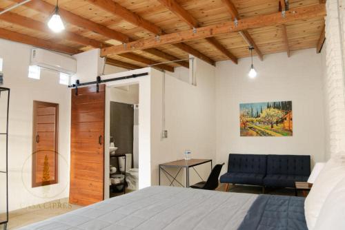 a bedroom with a bed and a couch in a room at Casa Ciprés in Valle de Guadalupe