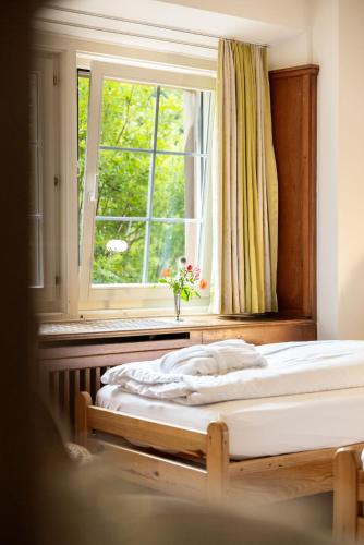 a bedroom with two beds in front of a window at Hotel Chesa Spuondas in St. Moritz