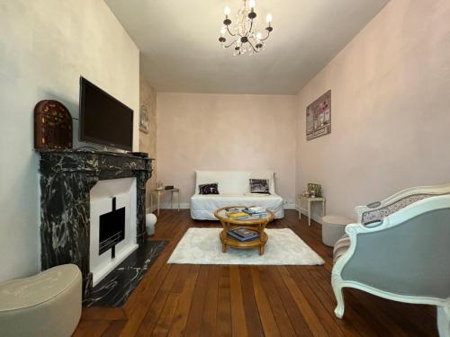 sala de estar con chimenea y cama en Appt 4pers à 150m du métro École vétérinaire - aux portes de Paris et Disney !, en Maisons-Alfort