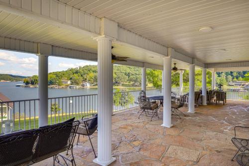 a porch with chairs and tables and a view of the water at Lake of the Ozarks Haven with Decks, Dock and Kayaks! in Roach
