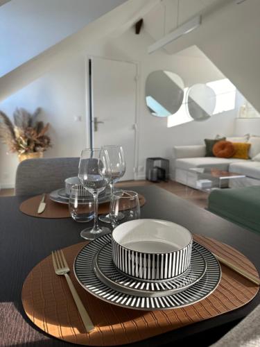 - une table à manger avec des assiettes et des verres à vin dans l'établissement L'Amour à la mer, à Honfleur