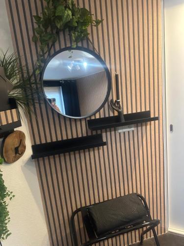 a mirror on a wall with a bench and a chair at Bed en Breakfast in Epe