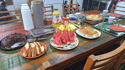 un tavolo con piatti di panini e frutta sopra di Chácara Maira e Araken a Ibiúna