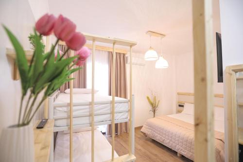 a bedroom with two bunk beds and a vase of flowers at Nidum Harmony in Tirana