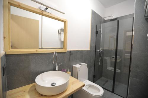 a bathroom with a sink and a toilet and a shower at Nidum Harmony in Tirana