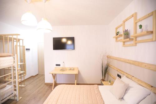 a small room with a bed and a table at Nidum Harmony in Tirana